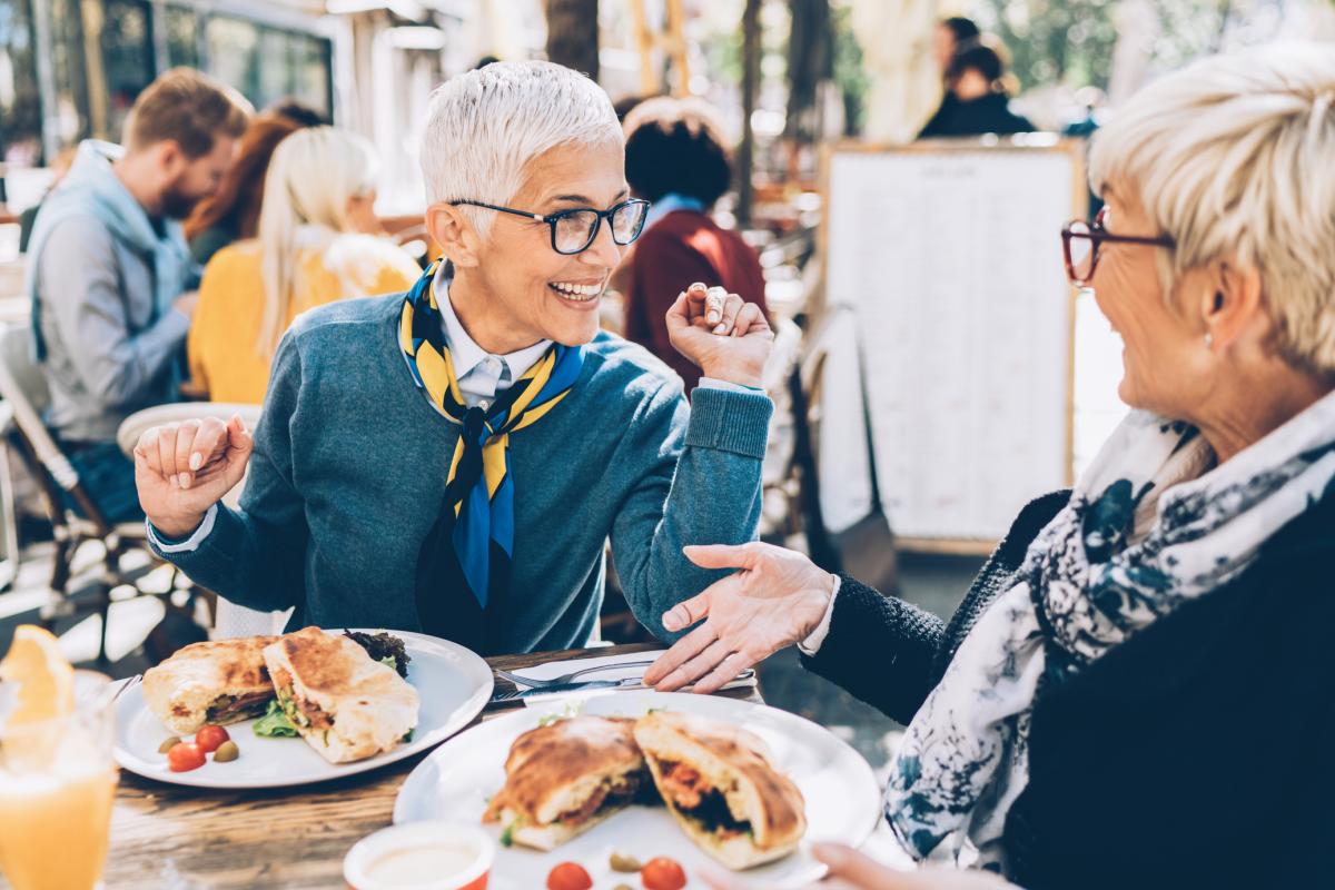 Dos amigas comiendo en una terraza.