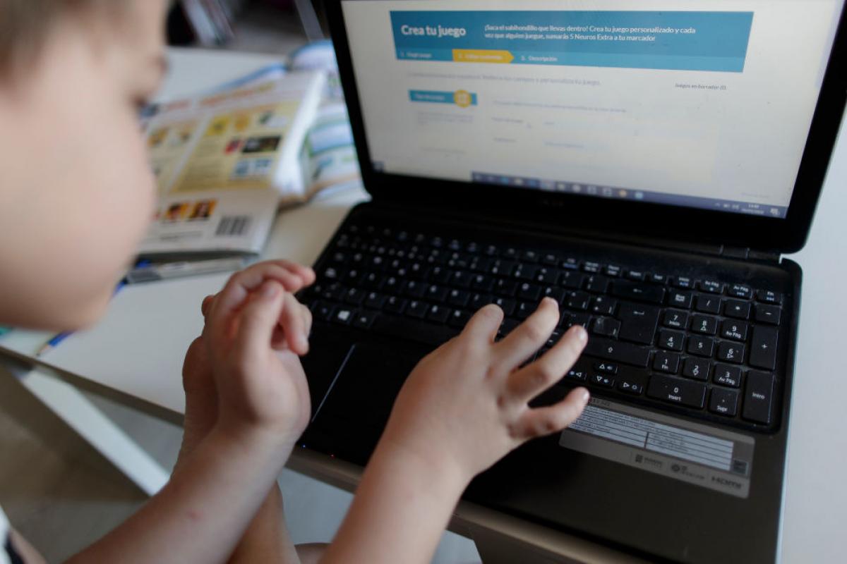 Un niño hace deberes del colegio en su ordenador