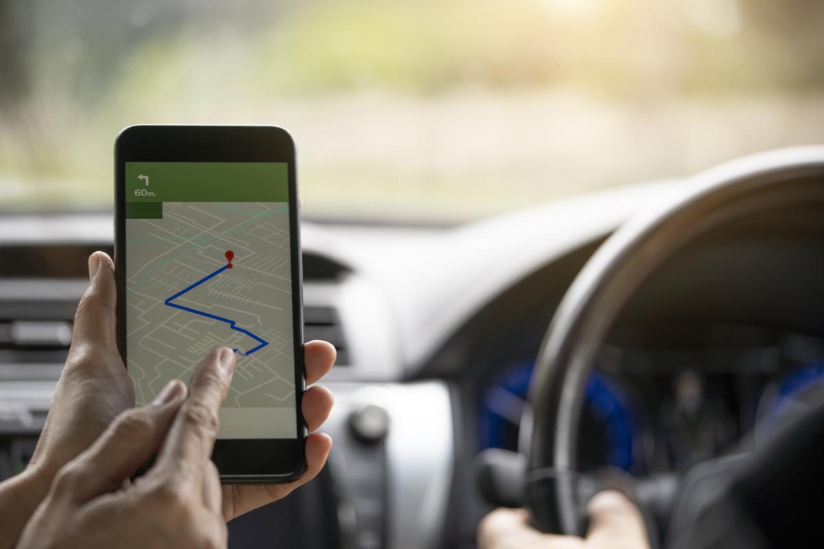Imagen de archivo de una persona indicando una dirección al conductor de un coche, en Google Maps.