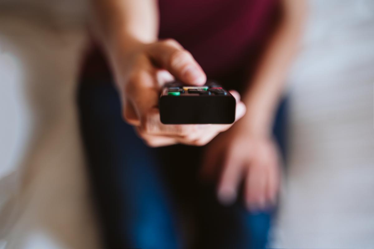 Imagen de archivo de una persona con un mando a distancia.