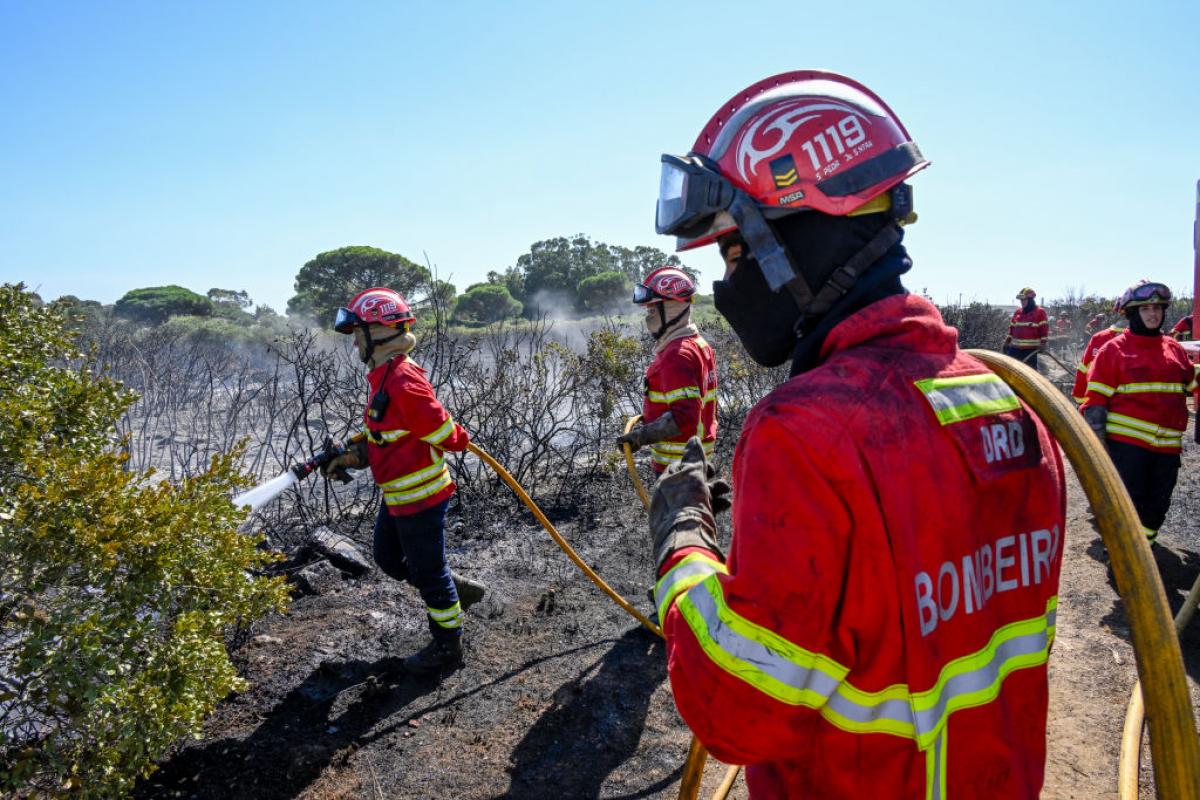 Una unidad de bomberos trabaja en el enfriamiento del terreno en Cascais, Portugal.
