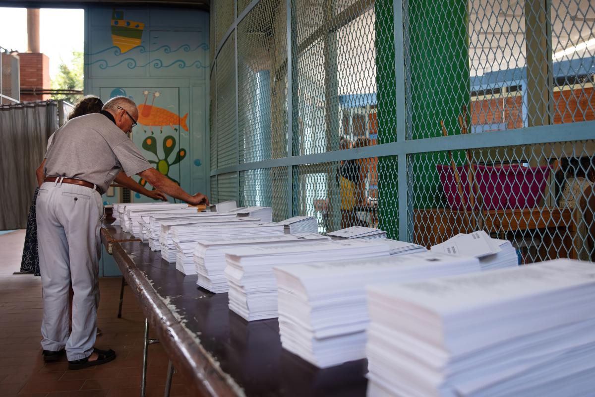 Imagen de archivo de varias personas ante las papeletas de las elecciones generales del 23J en la Escola Mercè Rodoreda, en Barcelona.