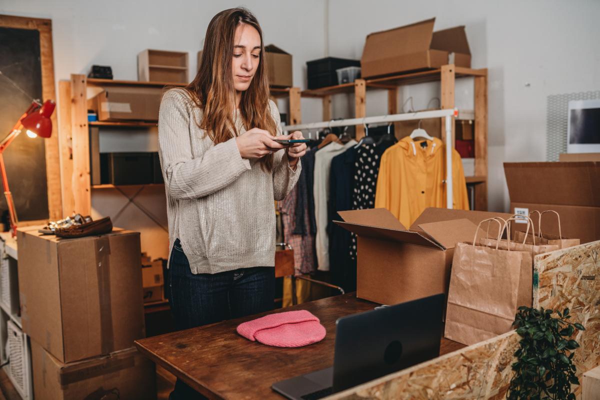 Una mujer vendiendo ropa a través de su móvil.