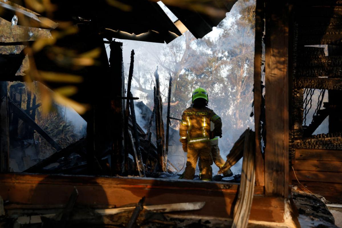Un bombero inspecciona los daños en una localidad de Líbano alcanzada por una bomba iraelí