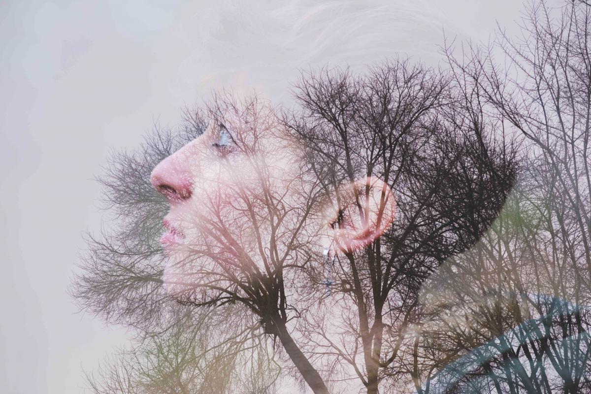 Mujer joven, vista lateral y árboles.