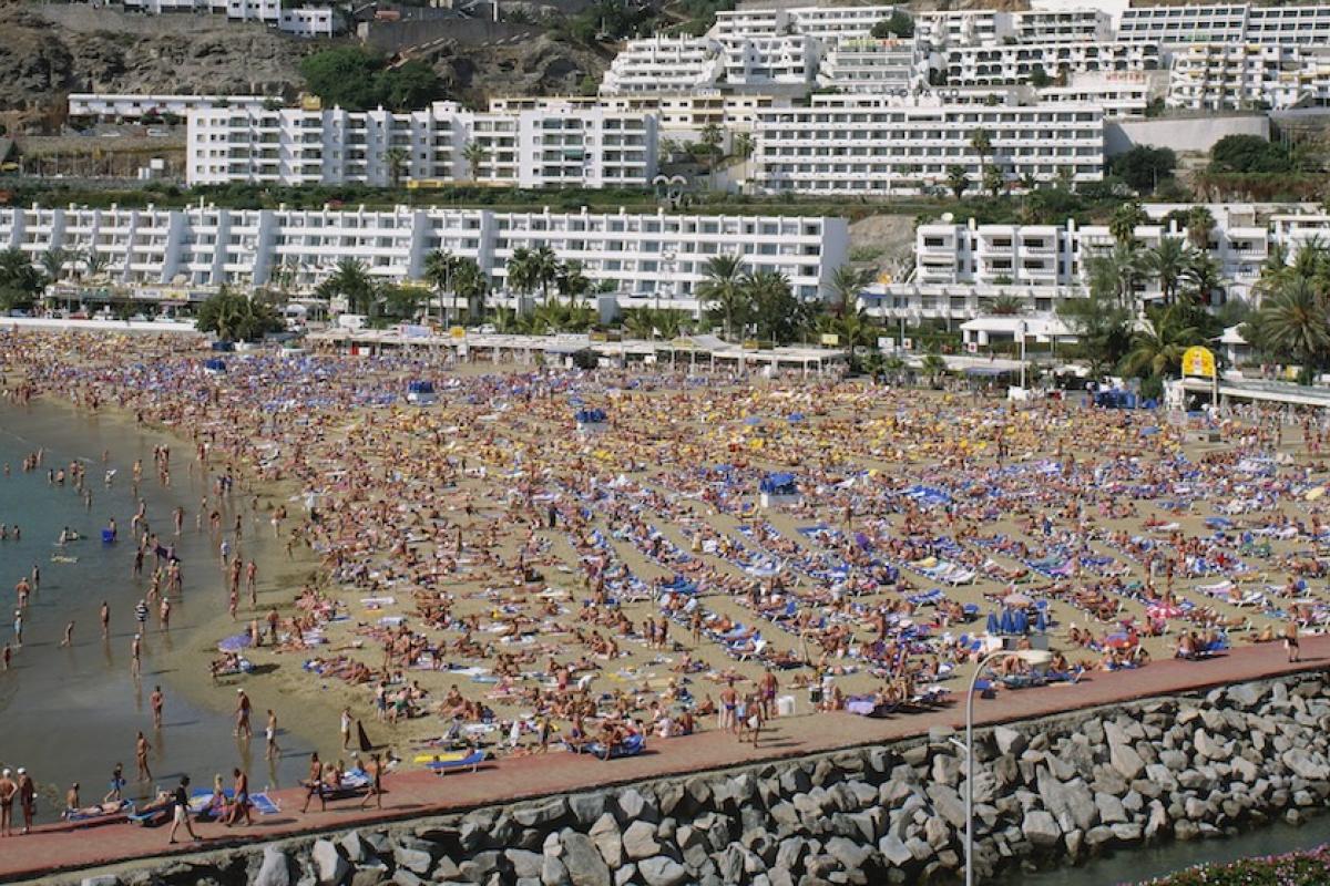 Panorámica de una playa de Gran Canaria abarrotada de turistas.