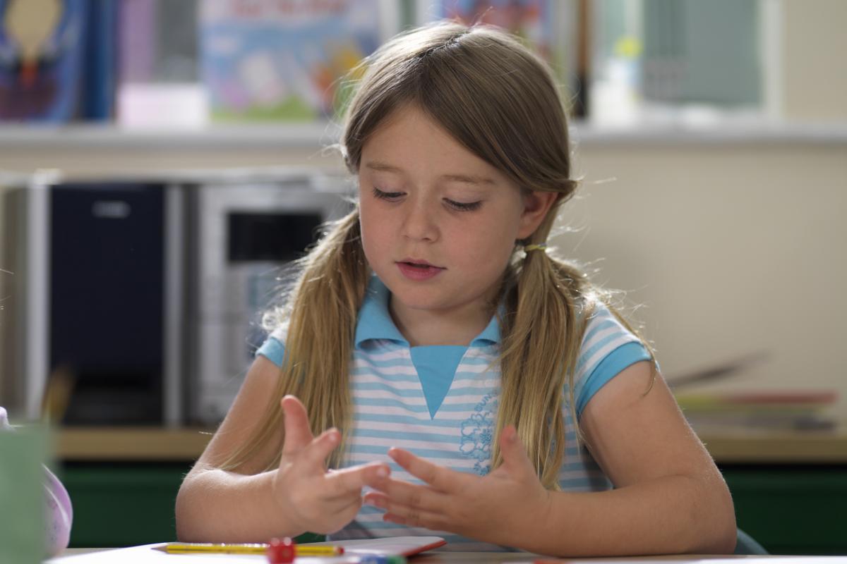 Una niña contando con los dedos.