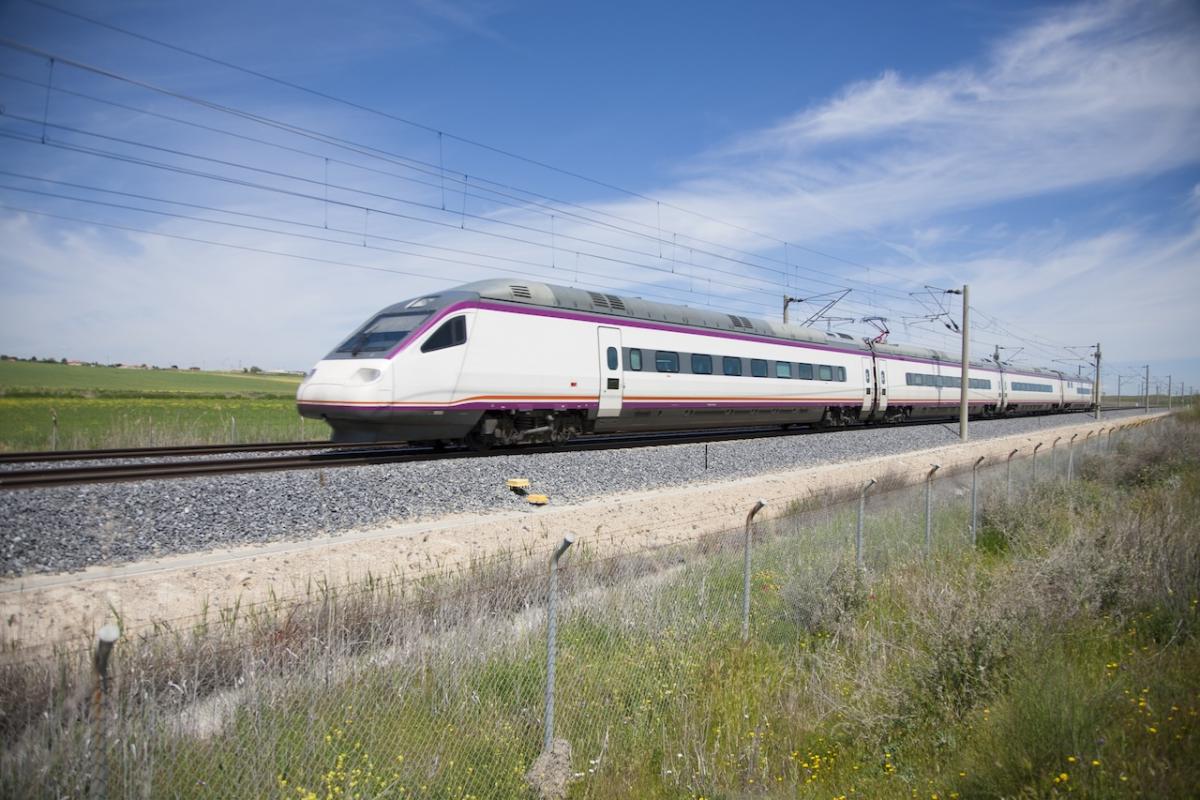 Un tren de Renfe atraviesa a toda velocidad el paisaje español.