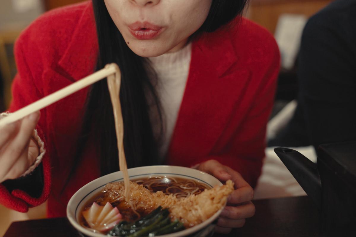 Imagen de archivo de una persona enfriando un bocado de fideos.