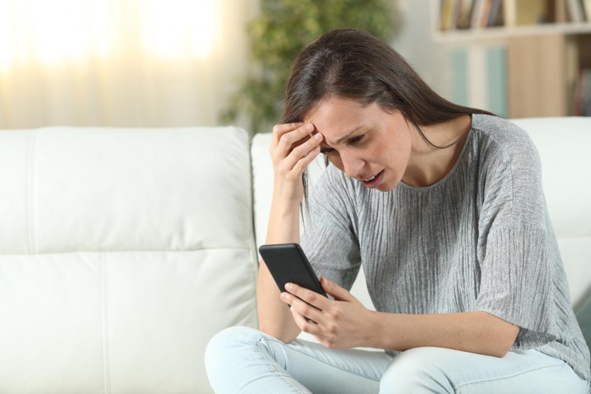 Una mujer agobiada chequea su correo electrónico.