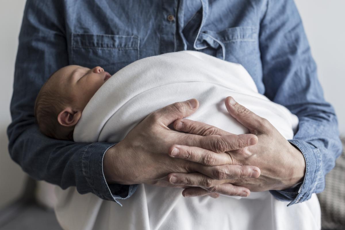 Un padre cuidando de un bebé, en una imagen de archivo.
