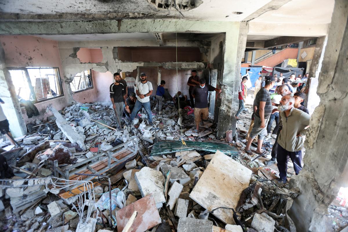 Palestinos comprueban los daños en el bombardeo israelí a una escuela en Deir Al-Balah (Gaza central).