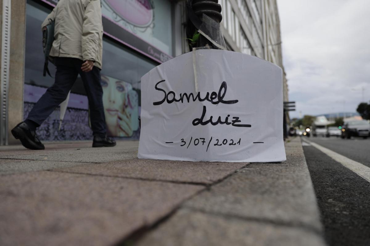 Un cartel con el nombre del brasileño Samuel Luiz situado en el lugar donde el joven recibió los golpes fatales que acabaron con su vida. El juicio por el asesinato de Samuel Luiz empieza el próximo miércoles 16 de octubre, en un proceso que tiene diez claves y en el que cinco acusados se enfrentan a penas de hasta 27 años de prisión, con dos menores ya condenados.