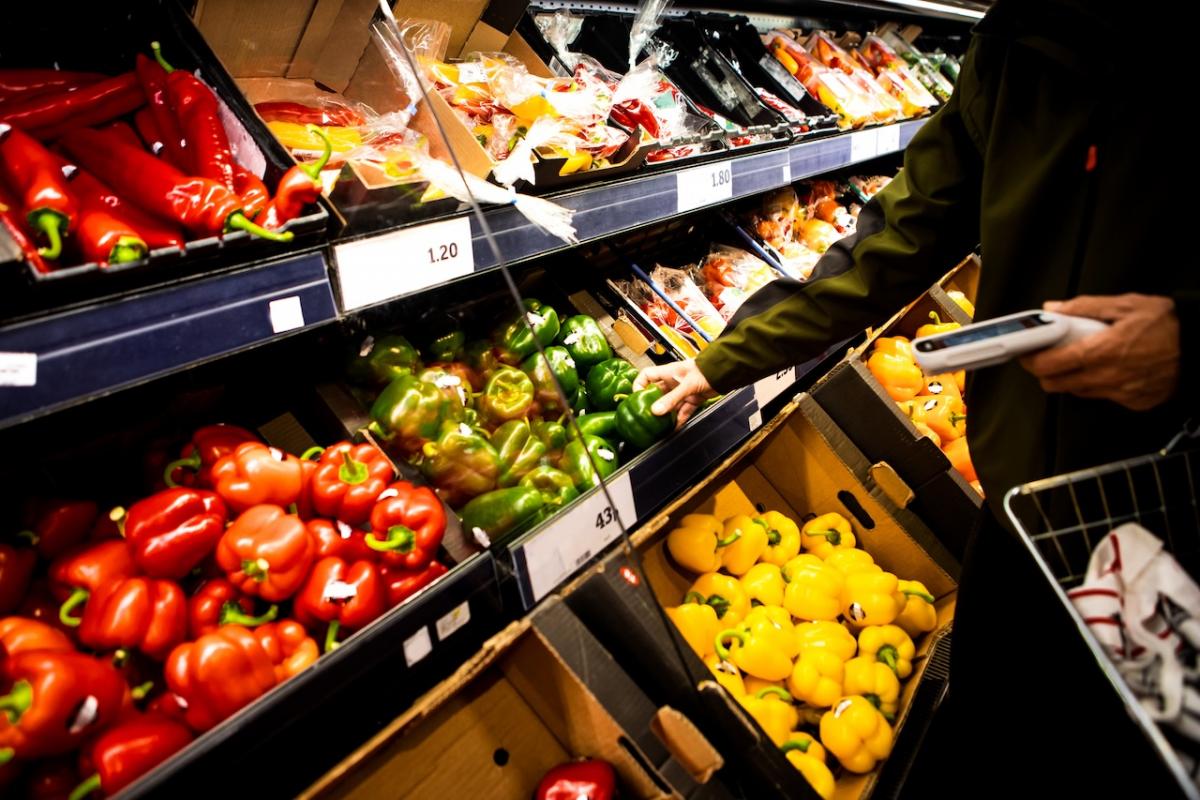 Un cliente selecciona unos pimientos en un supermercado de Reino Unido.