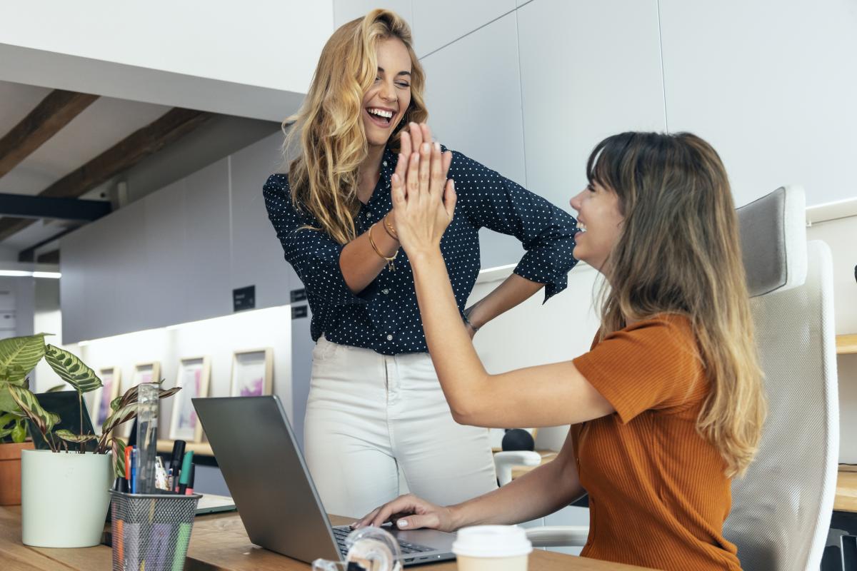 Dos personas chocando las manos en una oficina.