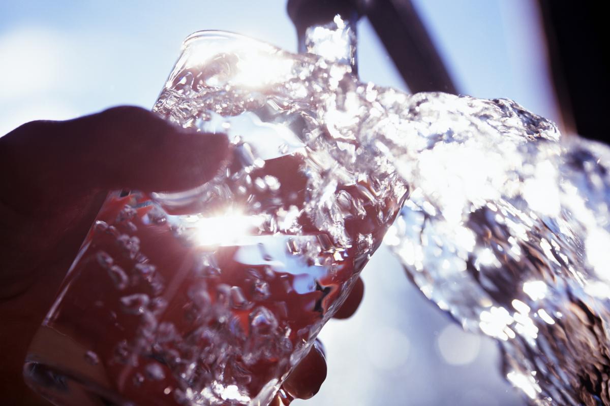 Un vaso llenándose con agua del grifo.