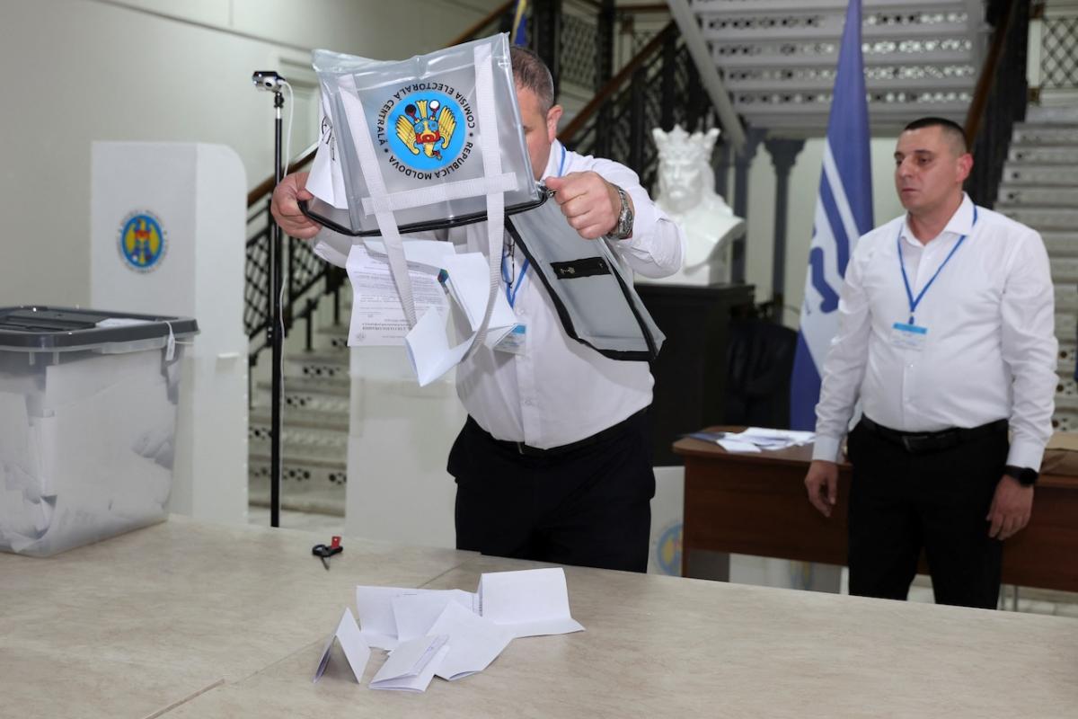 Un miembro de una mesa electoral procede al recuento de votos en las elecciones presidenciales y el referéndum por la adhesión de Moldavia a la Unión Europea.