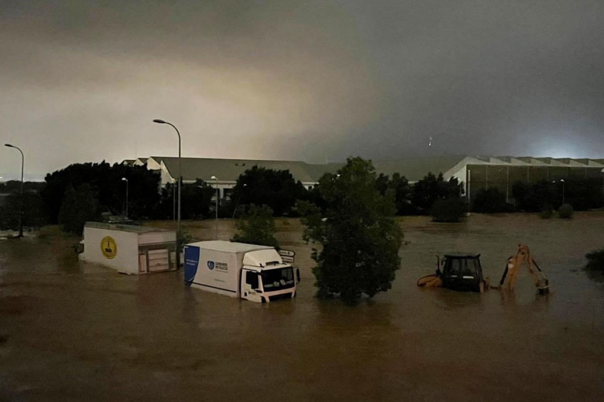 Camiones y un vehículo de construcción parcialmente sumergidos en las inundaciones que han tenido lugar en la provincia de Valencia
