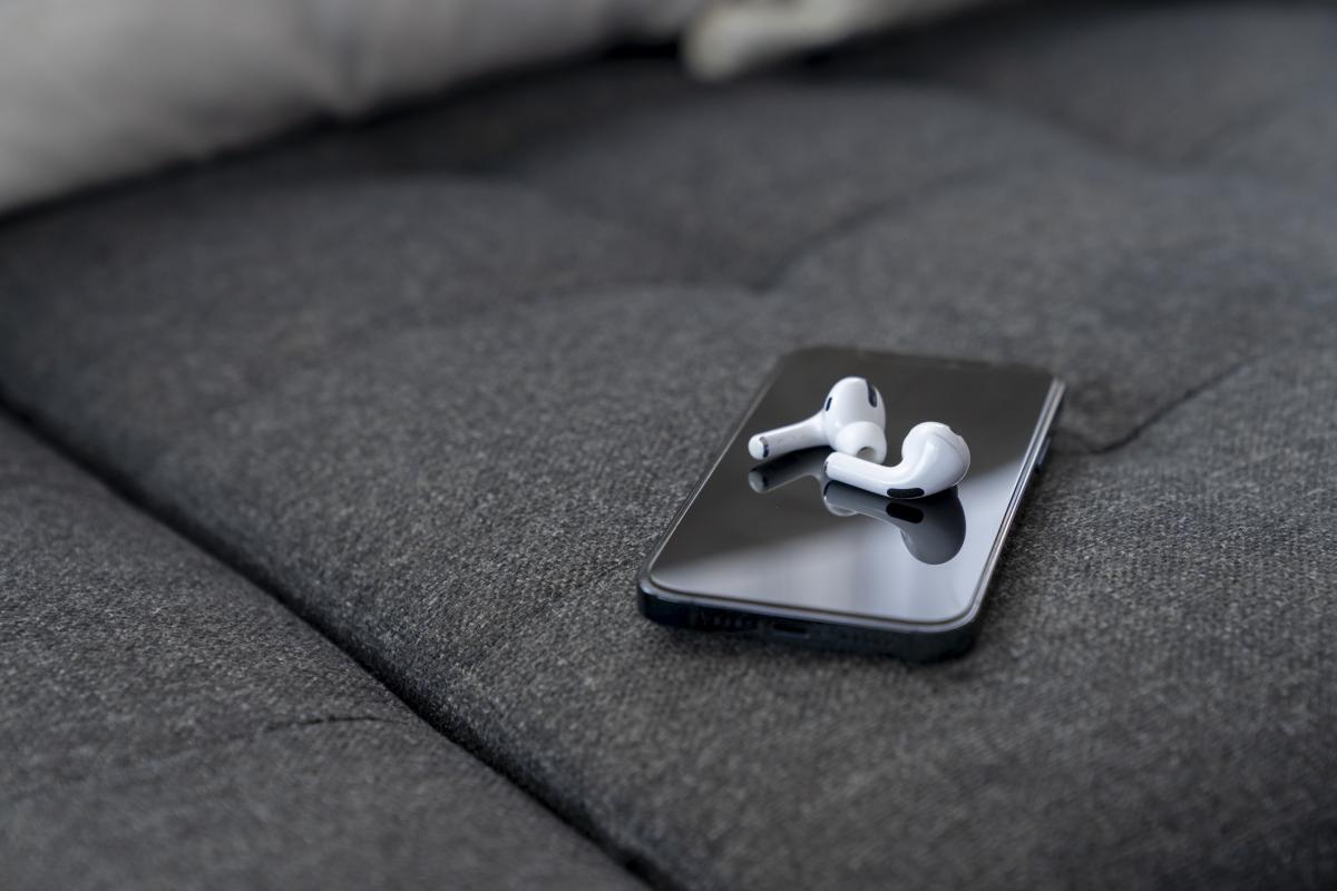 Imagen de archivo de un teléfono móvil con unos auriculares inalámbricos.