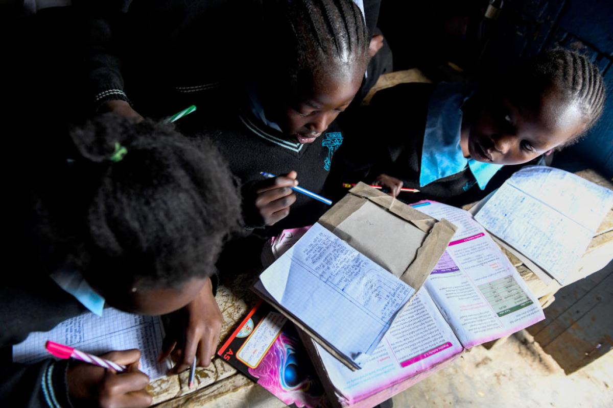 Tres jóvenes estudiantes de Nairobi hacen sus tareas en un colegio de la capital keniata.
