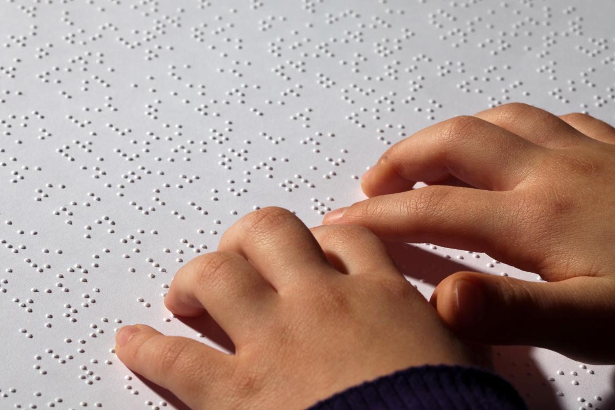 Un niño leyendo braille.