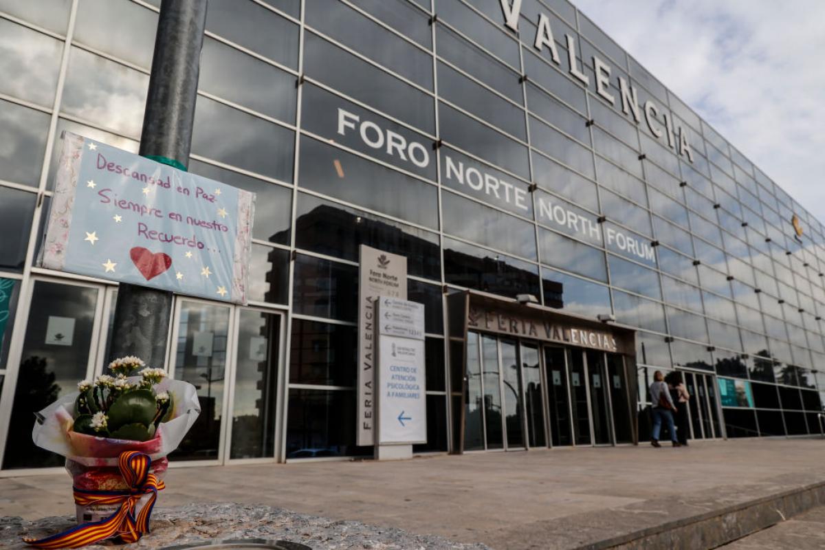 Flores y un cartel en recuerdo de las víctimas de la DANA a la entrada de la Feria de Valencia, que sirve de morgue tras el desastre