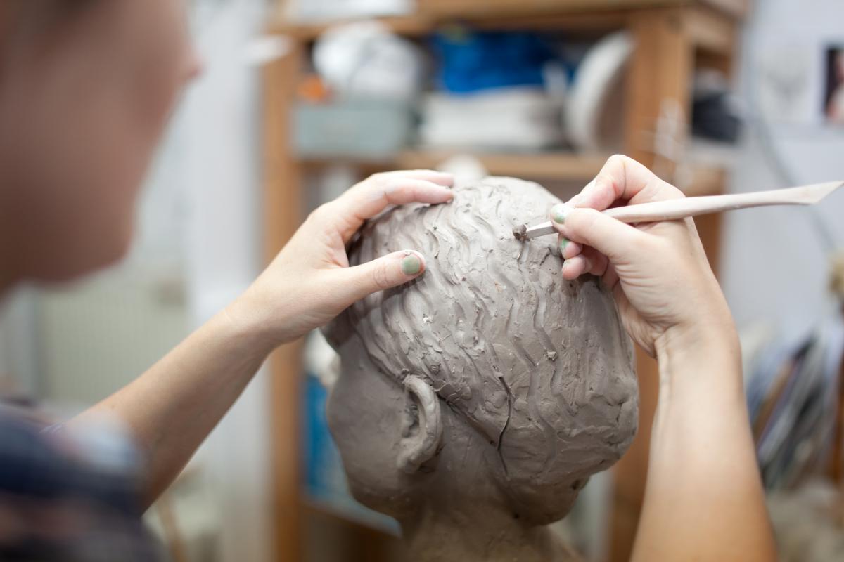 Foto de archivo de una persona con una escultura.