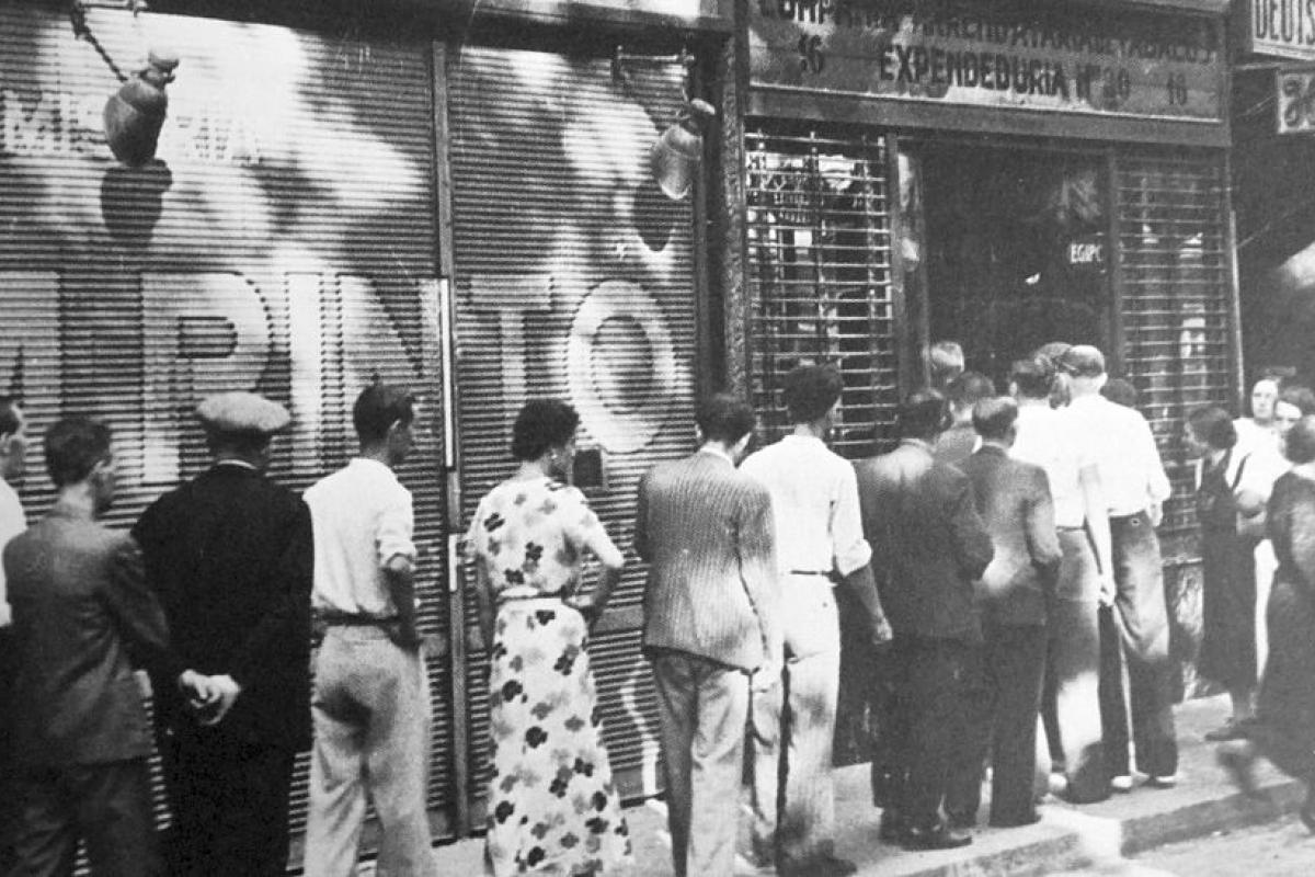 Unos ciudadanos recogen sus cartas de racionamiento en una calle de Barcelona, en 1937, plena Guerra Civil Española.