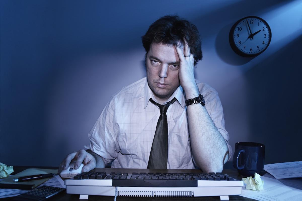 Un trabajador muy cansado, trabajando hasta altas horas de la noche.