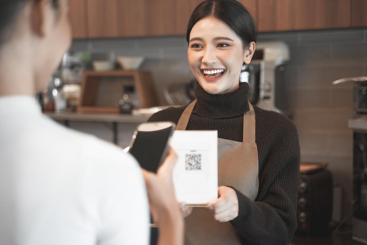 Un cliente escanea el QR de la carta de una cafetería.
