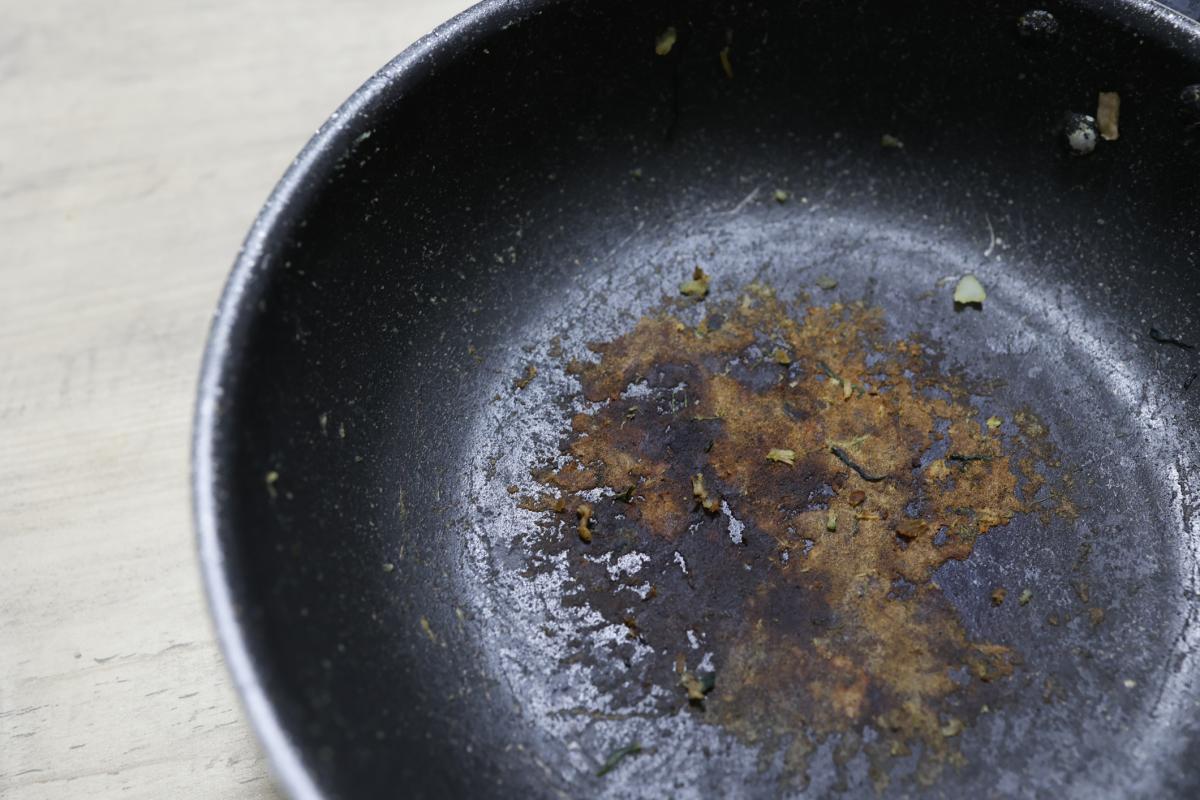 Sartén con restos de comida pegados.