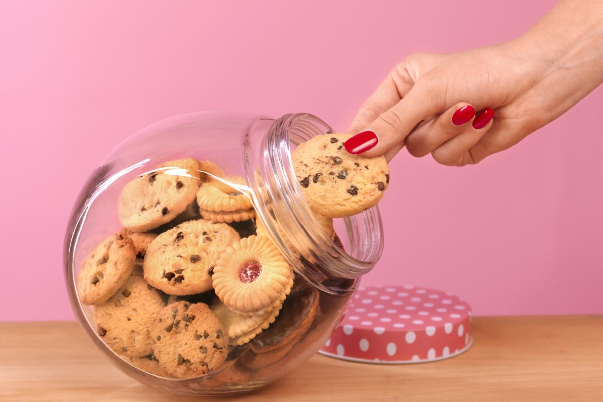 Una persona cogiendo galletas de un tarro.