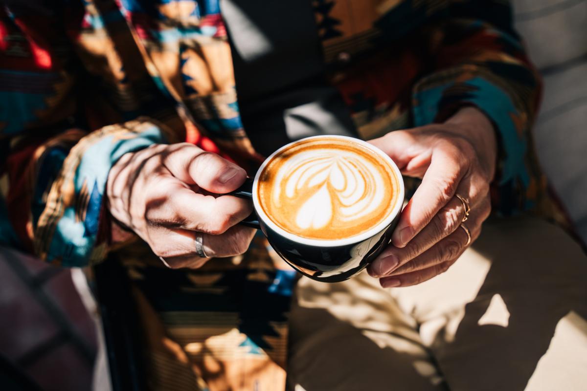 Una mujer sosteniendo un café.