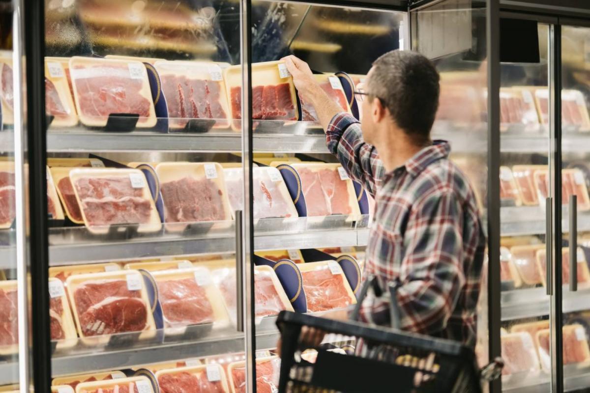 Hombre compra carne en supermercado