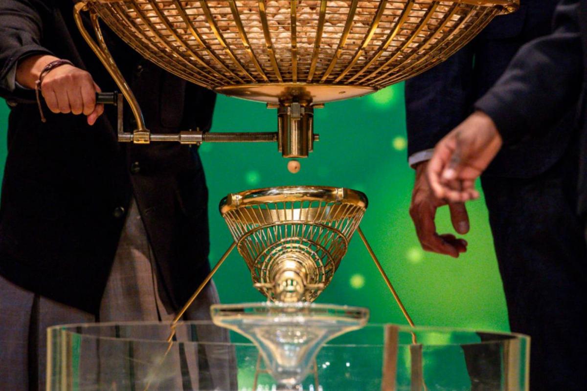 Sacando una bola afortunada en el bombo de la Lotería de Navidad