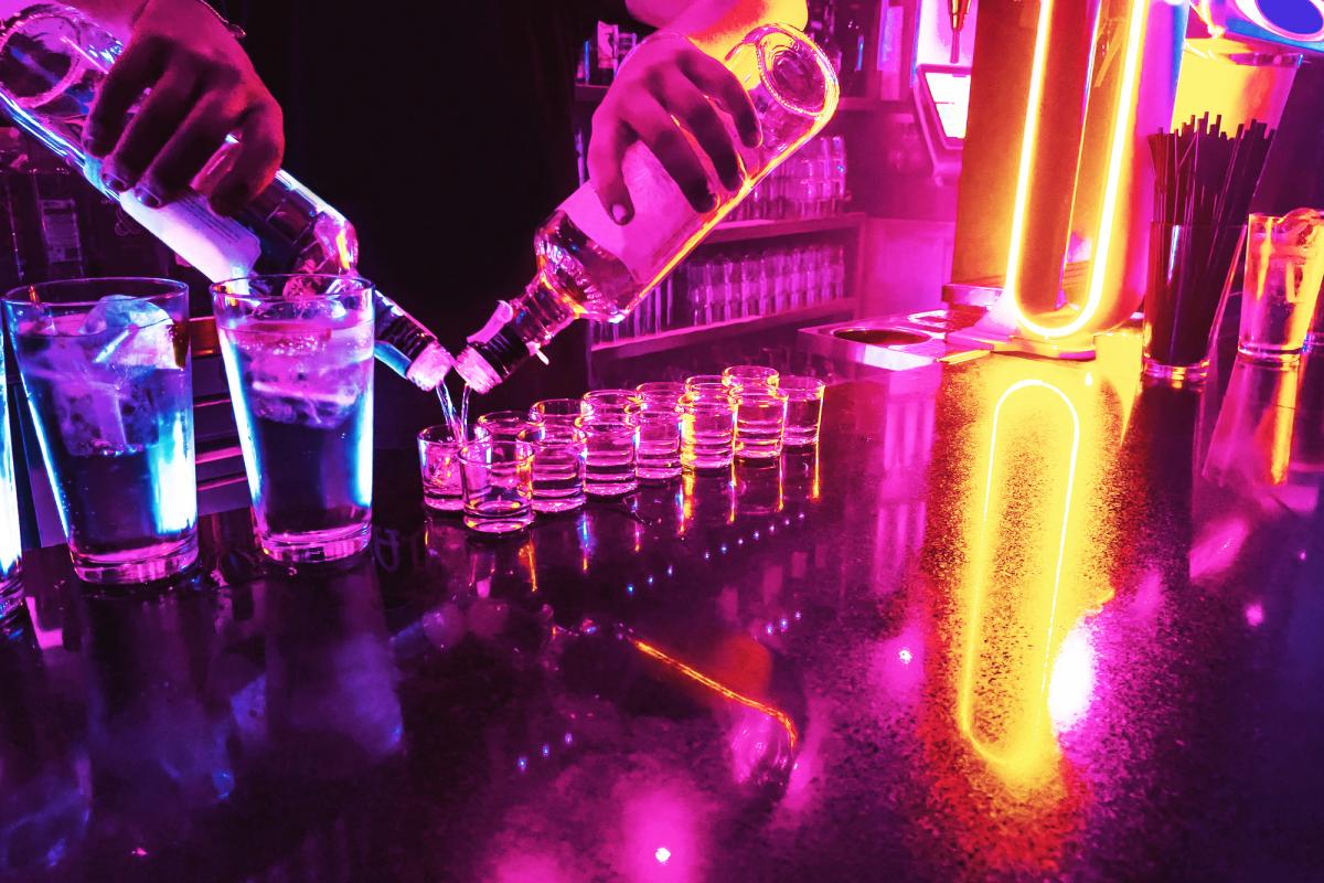 Un camarero sirve chupitos en una discoteca.