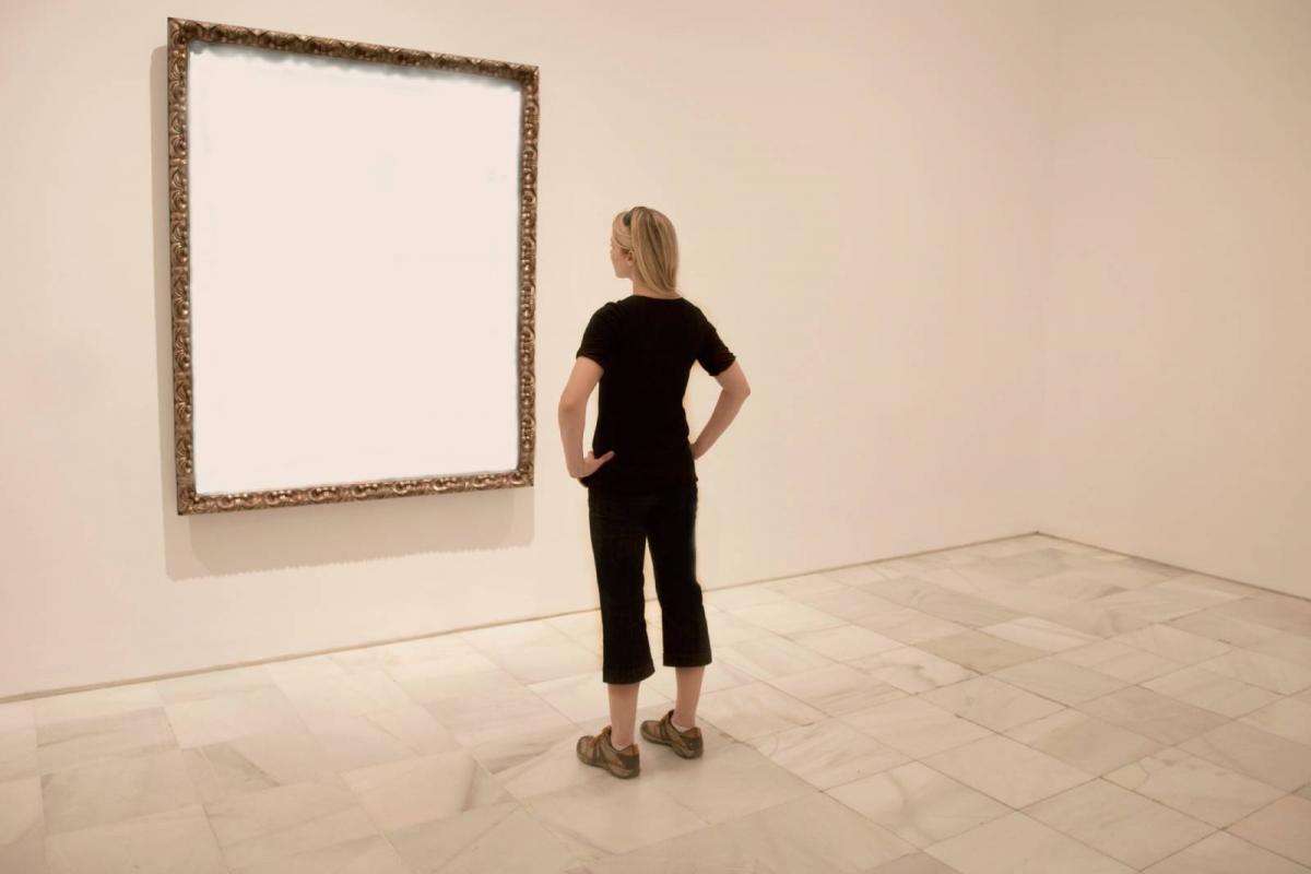 Mujer observa un cuadro vacio
