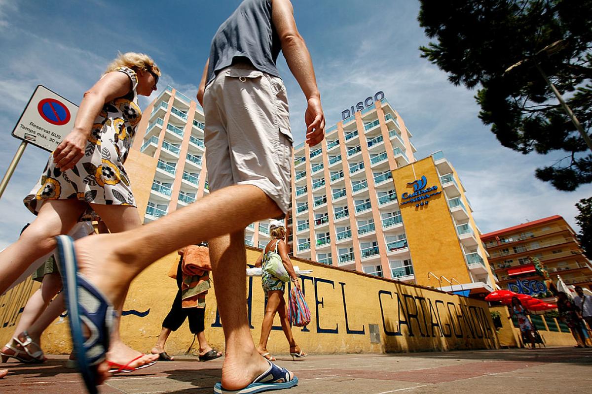 Turistas británicos pasan junto a un hotel en la población catalana de Santa Susana.