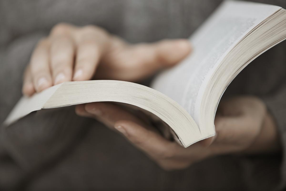 Un adulto sosteniendo un libro.