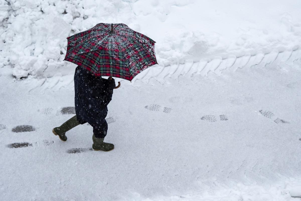 Imagen de archivo de un hombre caminando en la nieve.