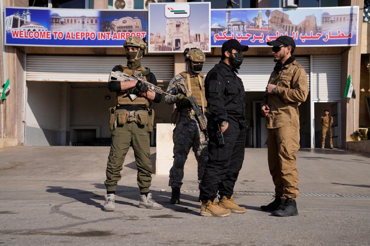 Milicianos controlan el primer vuelo desde el aeropuerto de Damasco al de Alepo, en esta última ciudad.