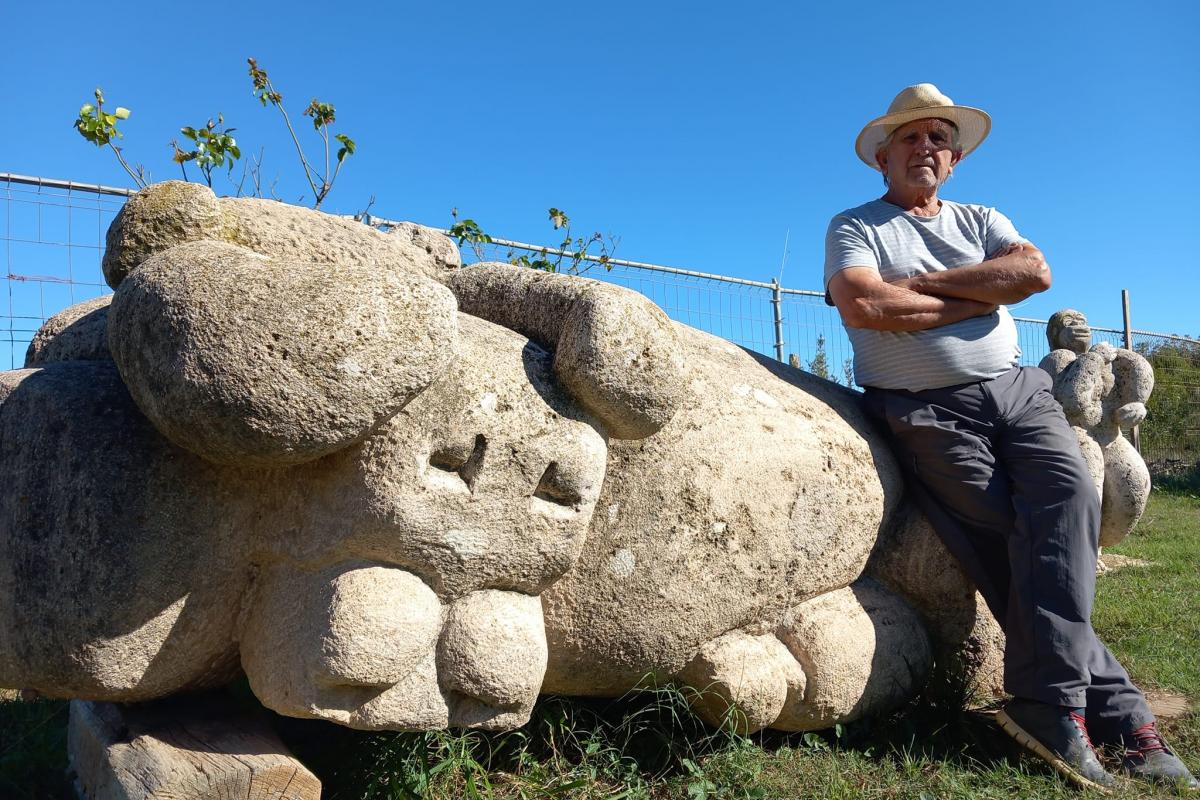 El escultor Antonio Sánchez, de Chiva, sentado en su taller sobre una de sus esculturas.