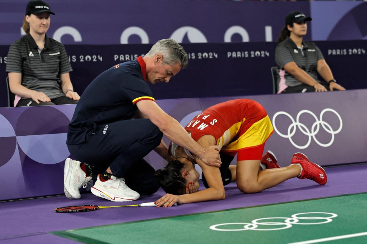 Carolina Marín, consolada por su entrenador, Fernando Rivas, tras lesionarse en las semifinales de París 2024