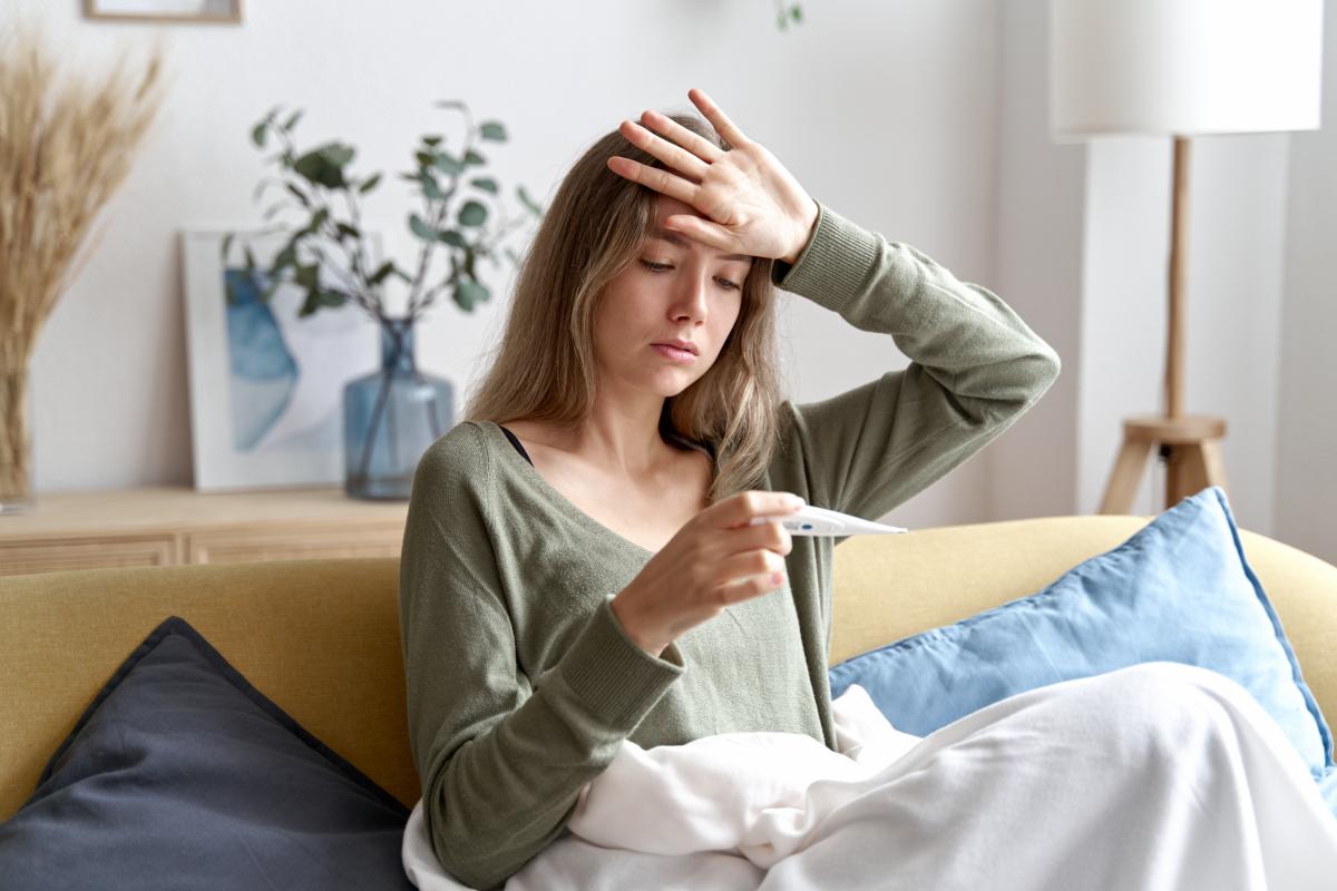 Una mujer usando el termómetro.