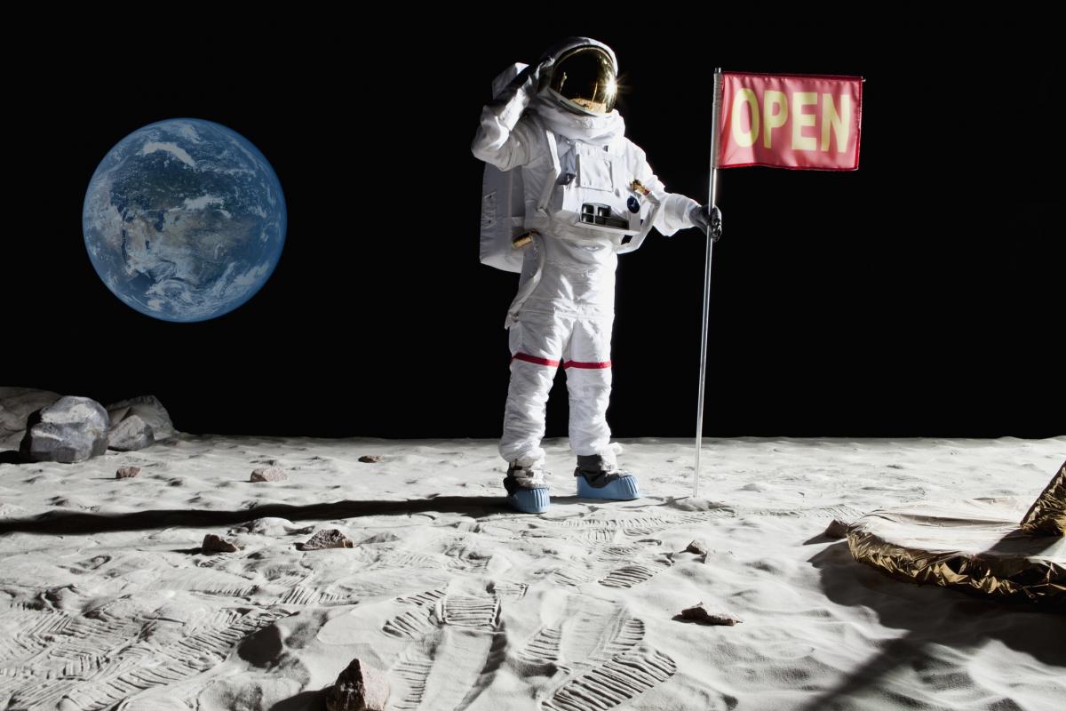 Ilustración de un astronauta con una bandera en la que se lee "abierto", en la Luna.