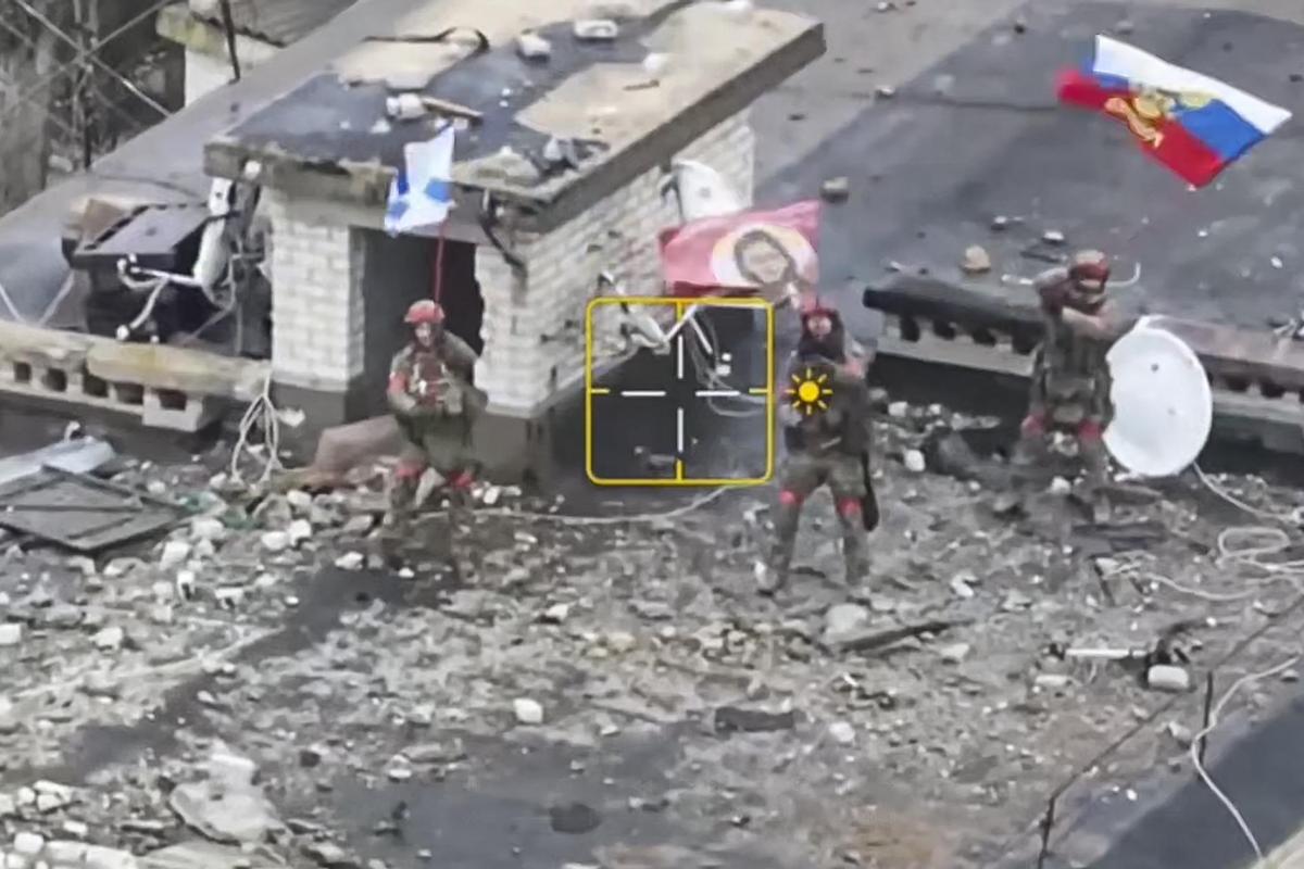 Una imagen tomada de un vídeo proporcionado por el Ministerio de Defensa ruso el 26 de enero de 2025 muestra a militares rusos ondeando banderas en el tejado de un edificio en Velyka Novosilka