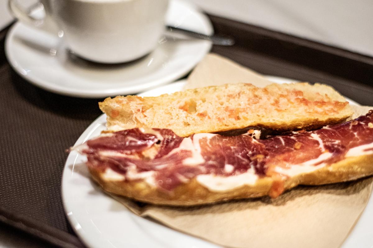 Un desayuno con una tostada con jamón serrano.