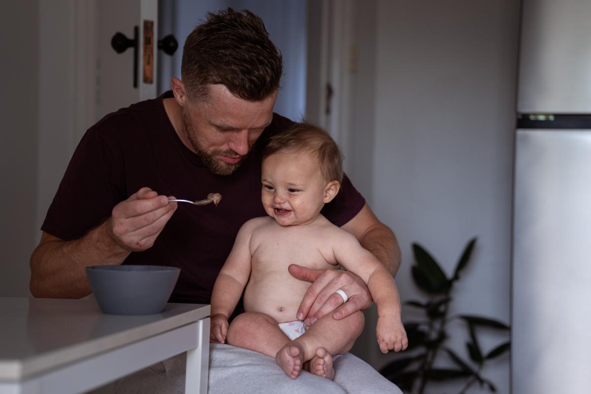 Un padre da de comer a su bebé.