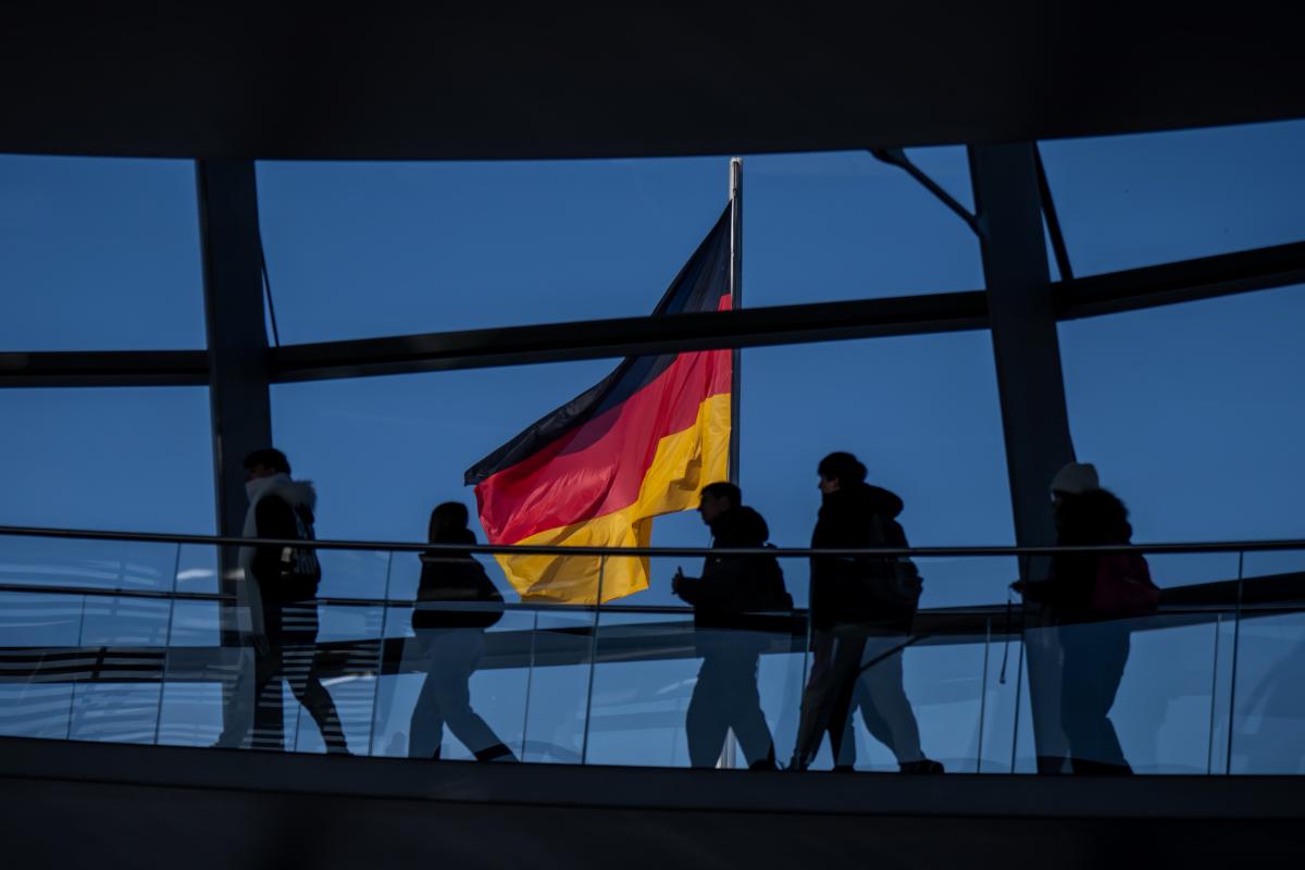 Personas con una bandera de Alemania de fondo.