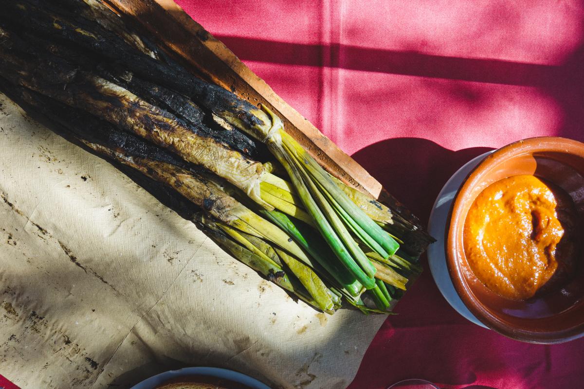 Unos 'calçots' a la brasa con su salsa romesco.